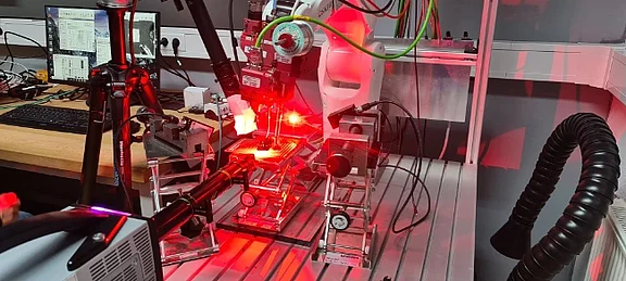 Versuchsaufbau im Labor zur Untersuchung eines Laserprozesses mit rotem Laserlicht