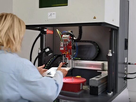 Bedienerin an einer Maschine zum Laserlöten von Bauteilen
