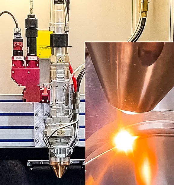 Laserauftragsschweißen (Cladding) mit Bearbeitungskopf auf einem Metallbauteil